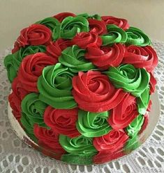 a cake with red and green frosting on a tableclothed doily is shown