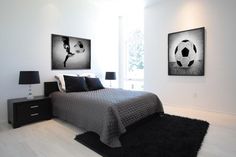 a bedroom with a soccer themed bed and two paintings on the wall, along with a black rug