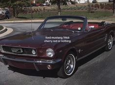 an old mustang convertible parked in a parking lot