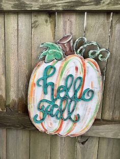 a painted pumpkin sitting on top of a wooden fence