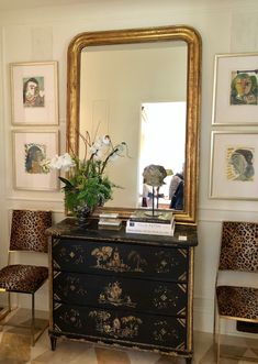 an ornate dresser and mirror in the corner of a room with leopard prints on the walls