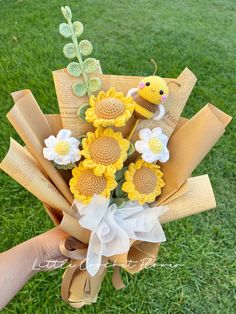 a bouquet of sunflowers is being held by someone's hand on the grass