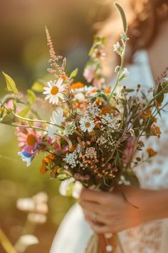 a woman holding a bouquet of flowers in her hands