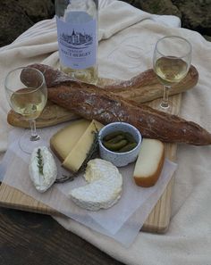 wine, bread and cheese are on a table