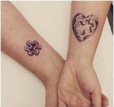 two people holding hands with matching tattoos on their arms and one has a puzzle piece in the shape of a heart