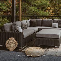 an outdoor furniture set on a deck with trees in the background