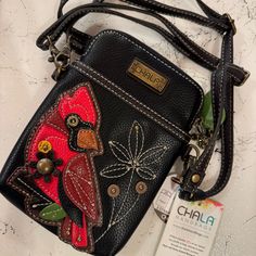 a black purse with a red bird on it