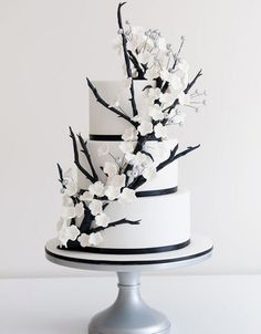 a white and black wedding cake with flowers on top