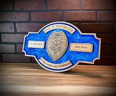 a police badge on top of a wooden table next to a brick wall in the background