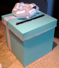 a large blue box with a bow on the top and diamond trimming around it