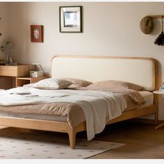 a bed sitting in a bedroom next to a wooden dresser and table with a clock on it