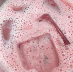 a close up view of a liquid in a blender filled with something pink and white