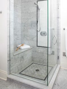 a glass shower door in a white bathroom