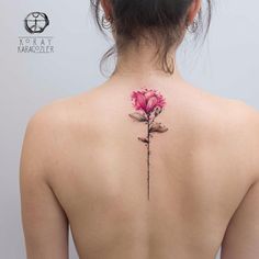 a woman's back with a flower tattoo on it