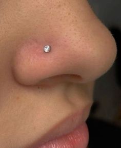 a woman's nose with a small diamond on the tip of her left lip