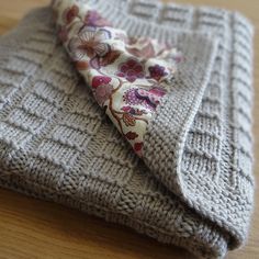 a close up of a sweater with a flowered tie laying on top of it