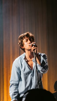 a man singing into a microphone on stage