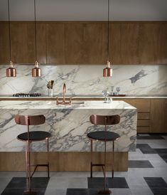 a kitchen with marble counter tops and bar stools