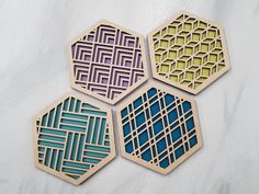 four wooden coasters with geometric designs on them