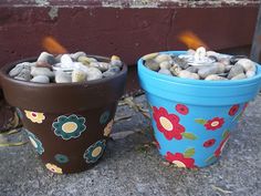 two flower pots sitting next to each other with rocks in them and flames coming out of them