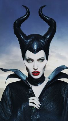 the maleficent character is wearing horns and holding a knife in his hand while looking at the camera