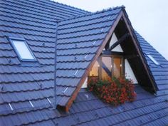 the roof of a house with flowers growing out of it