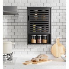 a kitchen with white subway walls and black cabinet doors that have spice racks on the wall