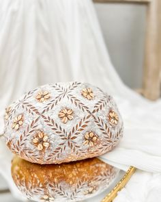 a loaf of bread sitting on top of a white plate next to a golden fork