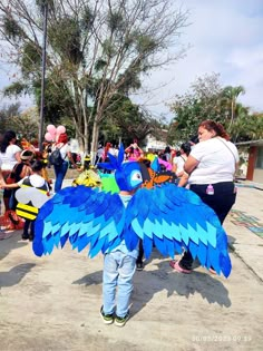 a young boy is dressed as a blue bird