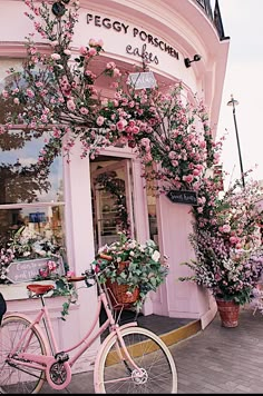 a pink bicycle is parked in front of a flower shop