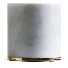 a white marble candle holder with gold trim