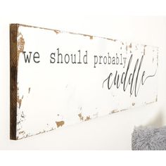 a wooden sign that says we should probably probably cuddle on the wall