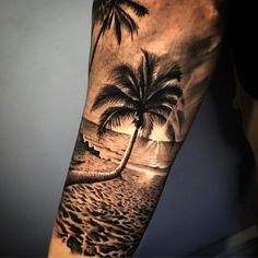 a man's arm with a palm tree on the beach