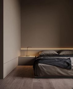 a bed sitting in a bedroom next to a lamp on a wall above it's headboard