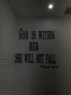 a white wall with black lettering that says god is within her she will not fall