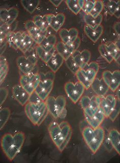 many heart shaped lights are shining brightly in the dark