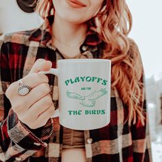 a woman holding a coffee mug with the words playboys and the birds on it