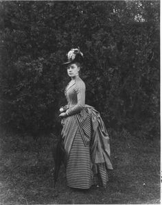 Twenty-two-year-old Miss E. Alice Austen poses in her Sunday best - a smart overskirt and a hat decorated with white lilacs. She holds a parasol and a silver change purse. Photo taken in June 1888 by Captain Oswald Muller. Alice Austen, Victorian People, Historical Garments, Victorian Dresses, Antique Dresses, 9 Lives, 1880s Fashion, Historical Dress