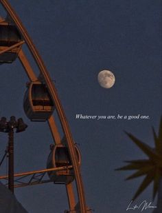 a ferris wheel at night with the moon in the sky and an inspirational quote written on it