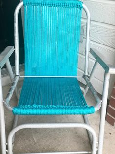 a blue lawn chair sitting next to a brick wall