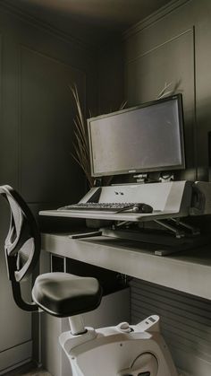 a computer desk with a monitor, keyboard and chair