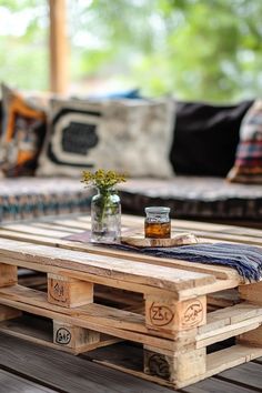 a table made out of wooden pallets with a vase filled with flowers on top