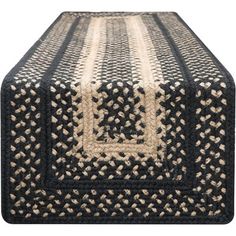 a black and white rug on top of a wooden table with a square design in the middle