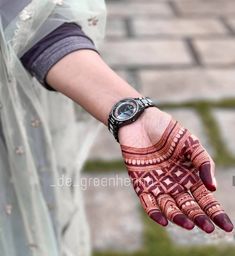 a woman's hand is decorated with hennap and wrist watch on it