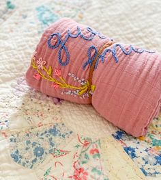 a pink pillow sitting on top of a quilt