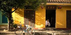 a bicycle parked in front of a yellow building