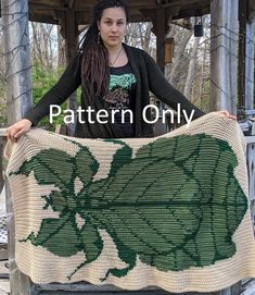 a woman holding up a crocheted green leaf blanket with the words pattern only on it