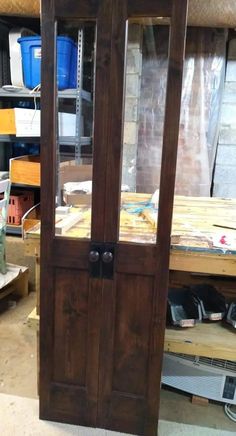 a large wooden door sitting inside of a room next to shelves filled with boxes and other items