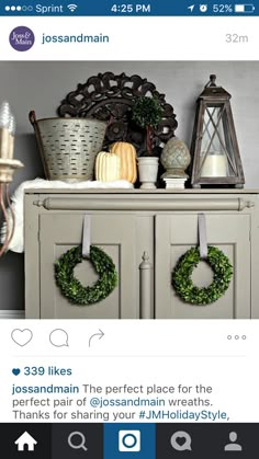 a cabinet with wreaths and candles on top