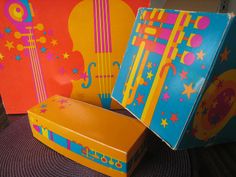 two brightly colored boxes with musical instruments painted on them